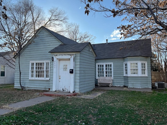 view of front facade featuring central AC unit and a front lawn