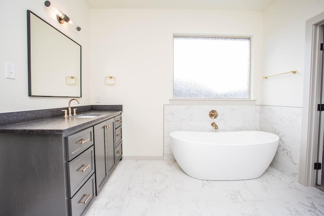 1312 Chaucer Ln, Wolfforth, TX 79382 - full bathroom with marble look tile flooring, vanity, a freestanding tub, tile walls, and wainscoting