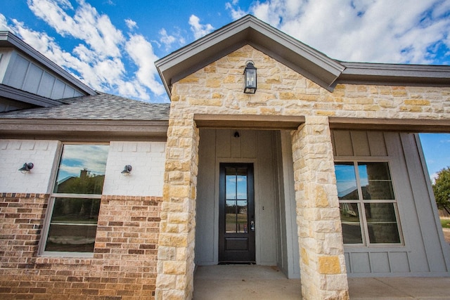1312 Chaucer Ln, Wolfforth, TX 79382 - property entrance with stone siding, board and batten siding, and a shingled roof