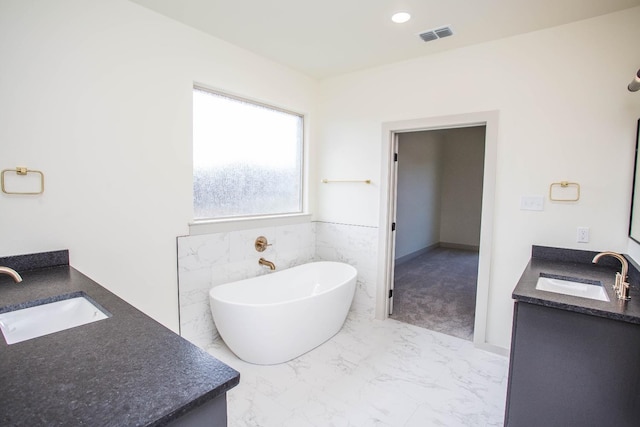 1312 Chaucer Ln, Wolfforth, TX 79382 - full bath featuring double vanity, a freestanding tub, marble look tile flooring, and recessed lighting