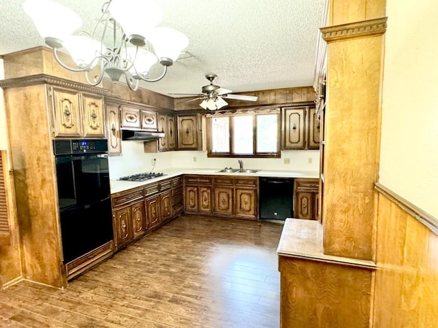 kitchen with ceiling fan with notable chandelier, sink, hardwood / wood-style flooring, black appliances, and a textured ceiling