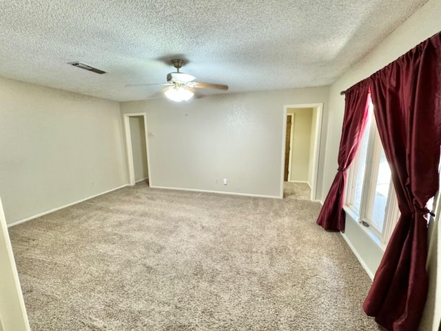 carpeted spare room with ceiling fan and a textured ceiling