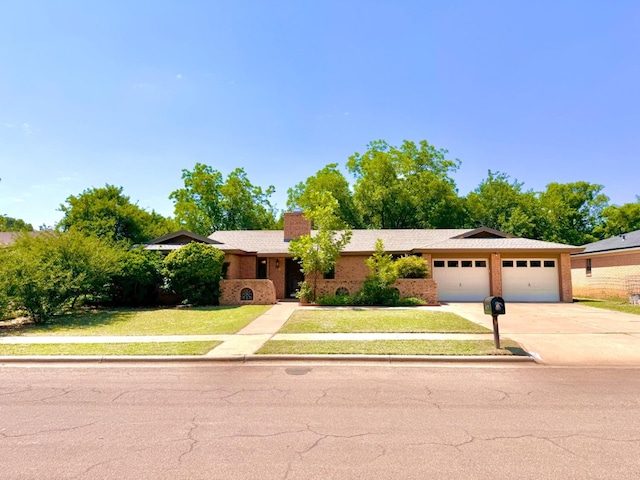 ranch-style home featuring a garage and a front lawn