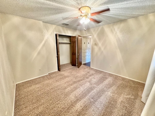 unfurnished bedroom with ceiling fan, a closet, carpet floors, and a textured ceiling