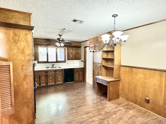 kitchen with sink, dishwasher, hanging light fixtures, hardwood / wood-style floors, and a textured ceiling