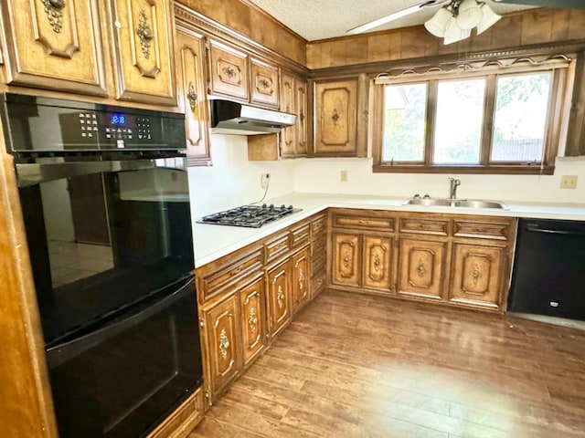 kitchen with black appliances, sink, ceiling fan, light hardwood / wood-style floors, and a textured ceiling