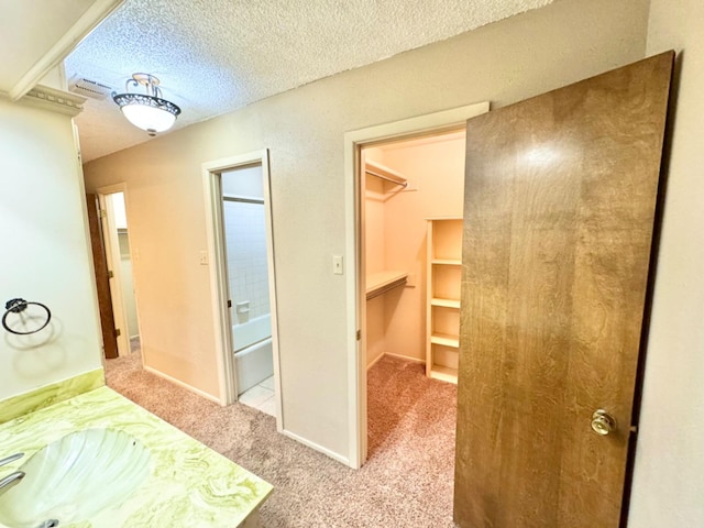 bathroom featuring vanity, shower / bathtub combination, and a textured ceiling