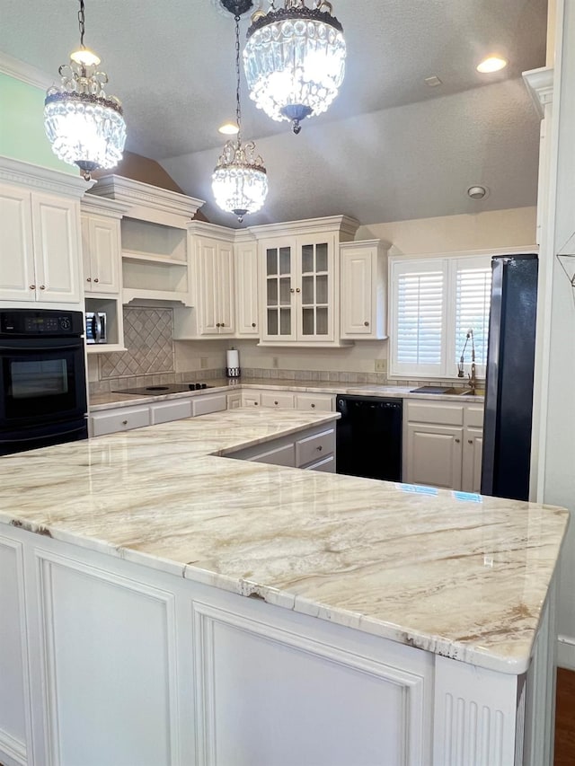 kitchen featuring white cabinetry, vaulted ceiling, hanging light fixtures, and black appliances