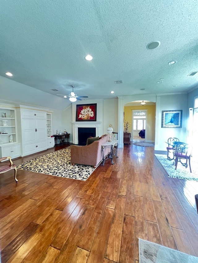 living room with hardwood / wood-style floors, a textured ceiling, and ceiling fan