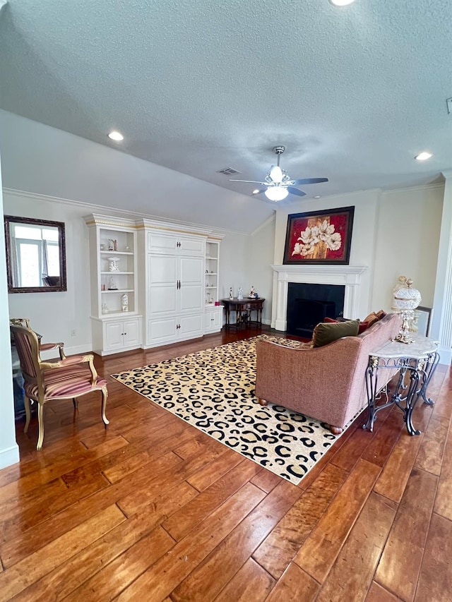 living room with ceiling fan, wood-type flooring, and a textured ceiling