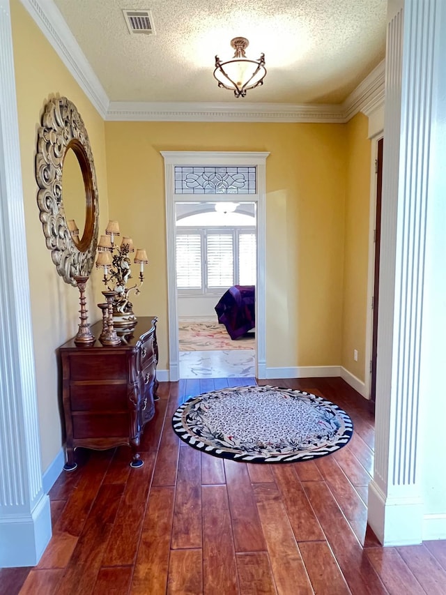 entryway featuring ornamental molding and a textured ceiling