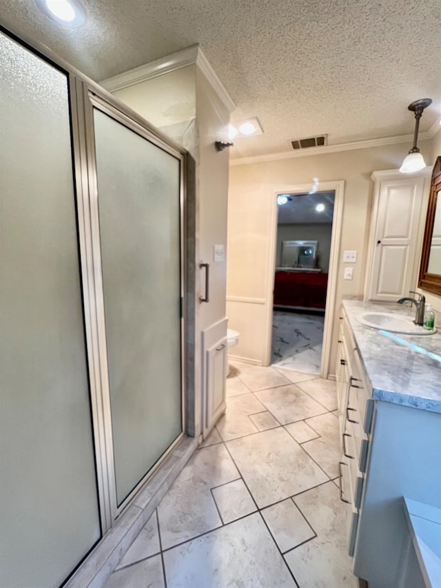 bathroom featuring walk in shower, ornamental molding, vanity, and a textured ceiling