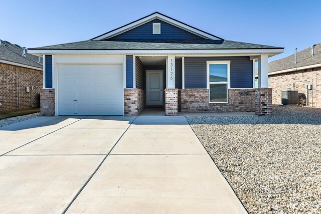 view of front of home featuring central AC unit, a garage, and a porch