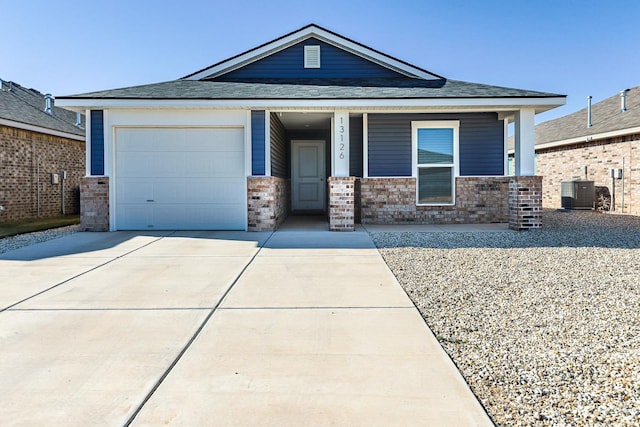 view of front of home featuring central AC unit, a garage, and a porch