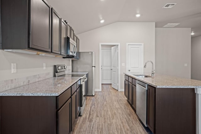 kitchen featuring sink, dark brown cabinets, light hardwood / wood-style flooring, appliances with stainless steel finishes, and a kitchen island with sink