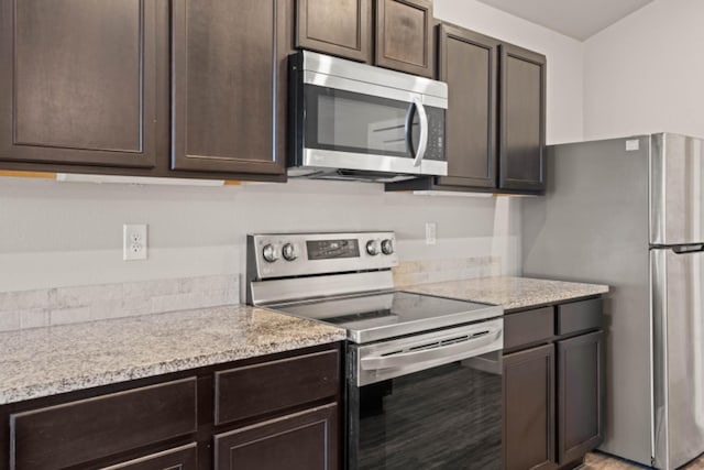 kitchen with light stone countertops, appliances with stainless steel finishes, and dark brown cabinets