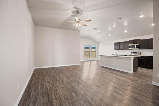 unfurnished living room featuring lofted ceiling, sink, dark hardwood / wood-style floors, and ceiling fan