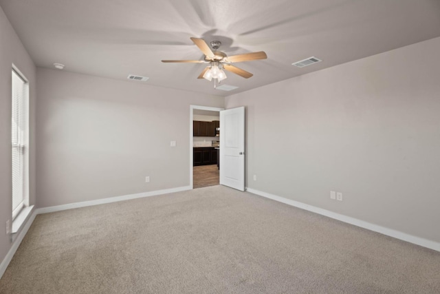 empty room with ceiling fan and carpet floors