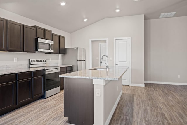 kitchen with sink, dark brown cabinets, a center island with sink, light hardwood / wood-style flooring, and stainless steel appliances