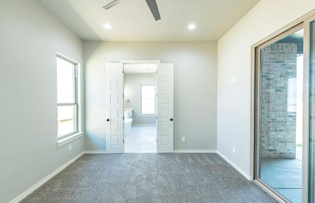 unfurnished bedroom with ceiling fan, carpet floors, and multiple windows