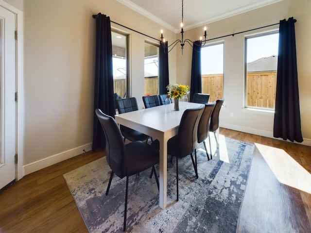 dining area with an inviting chandelier, hardwood / wood-style floors, and crown molding