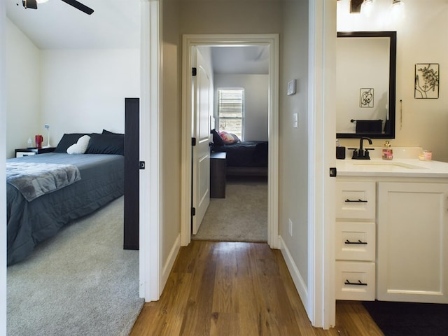 bedroom with light colored carpet and sink