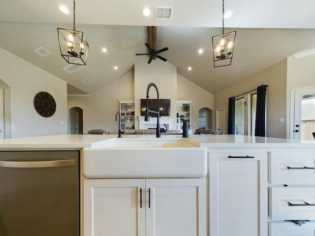 kitchen featuring sink, vaulted ceiling with beams, white cabinetry, hanging light fixtures, and stainless steel dishwasher