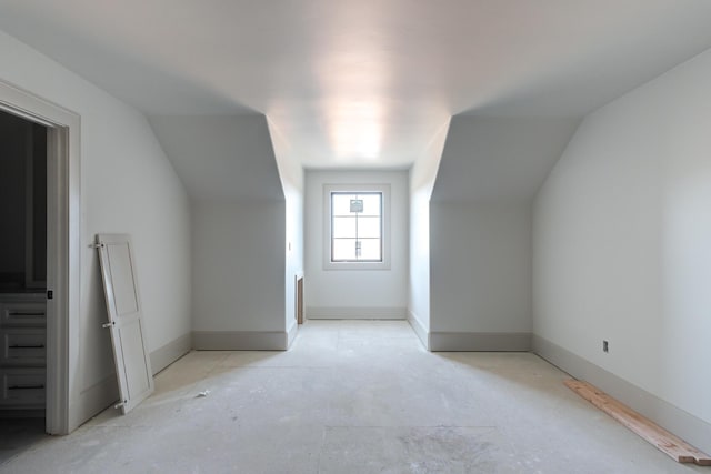 bonus room featuring lofted ceiling and baseboards