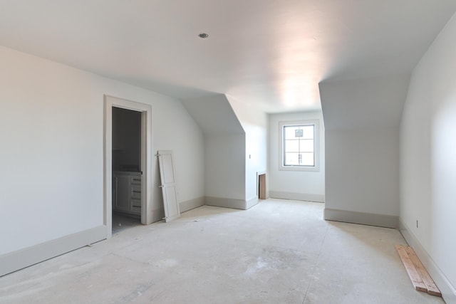 additional living space with vaulted ceiling and baseboards