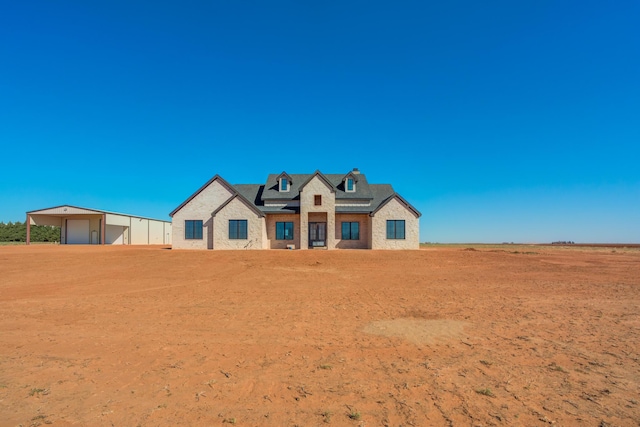 modern farmhouse featuring a detached garage, a carport, and roof mounted solar panels