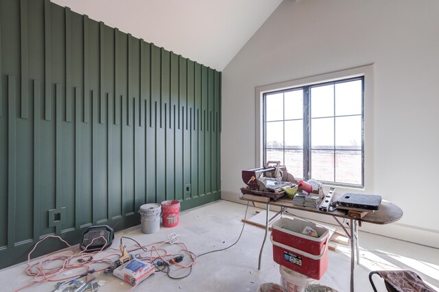 empty room with concrete floors and vaulted ceiling