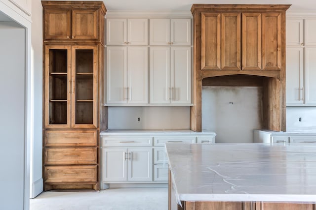 kitchen featuring brown cabinetry and white cabinets