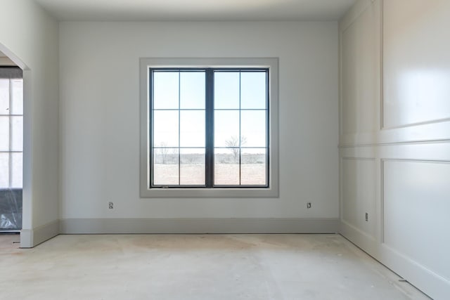 unfurnished room featuring unfinished concrete flooring and baseboards