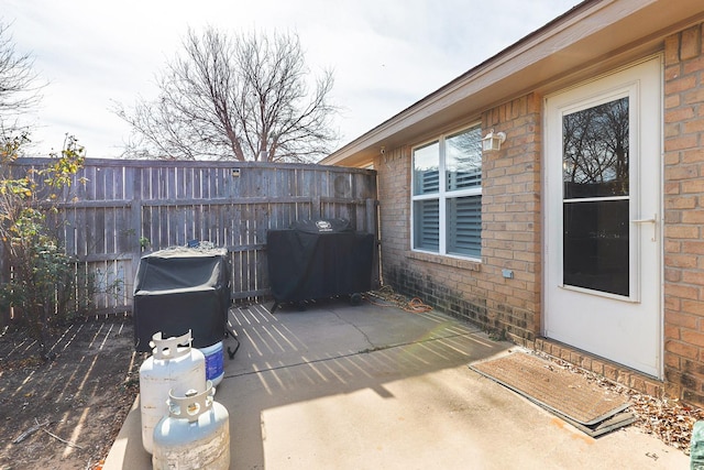 view of patio / terrace with a grill and fence