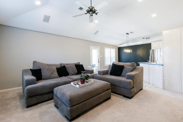 living room featuring lofted ceiling, light colored carpet, ceiling fan, and visible vents