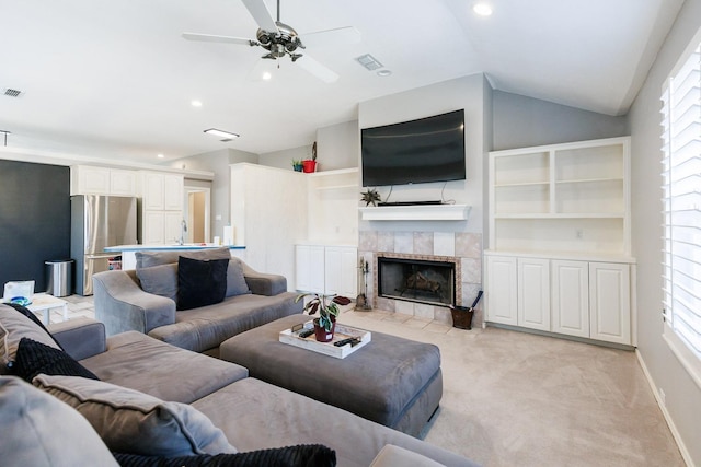 living area featuring a fireplace, lofted ceiling, light carpet, ceiling fan, and baseboards