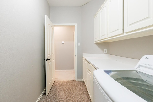 laundry area with washer / dryer, baseboards, cabinet space, and light colored carpet