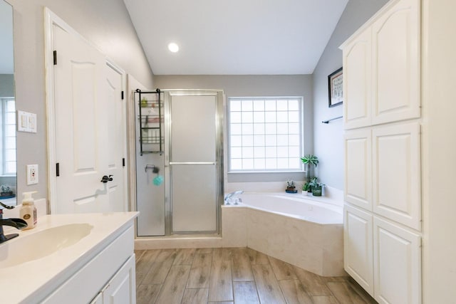 full bath with wood finished floors, a garden tub, vaulted ceiling, vanity, and a shower stall