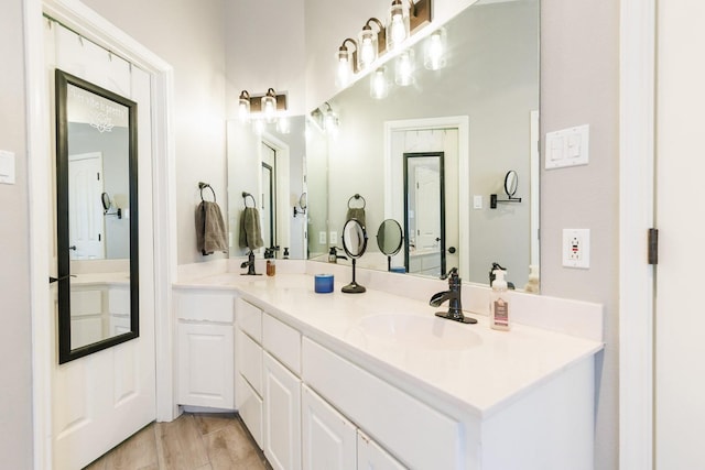 bathroom featuring double vanity, a sink, and wood finished floors