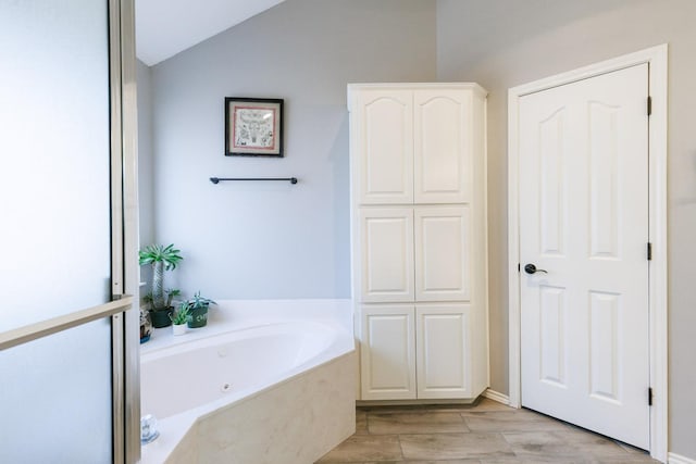 full bath featuring a garden tub and vaulted ceiling