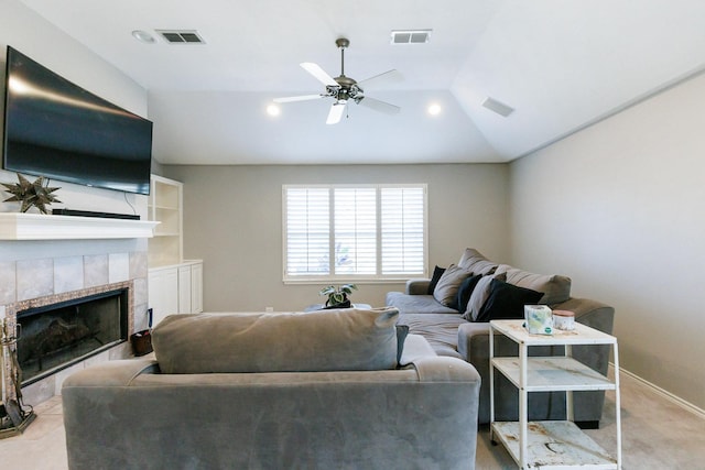 living area with lofted ceiling, visible vents, ceiling fan, a tile fireplace, and baseboards