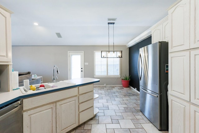 kitchen featuring stainless steel appliances, a sink, visible vents, hanging light fixtures, and light countertops