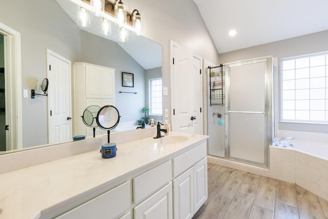 bathroom with vanity, vaulted ceiling, and independent shower and bath