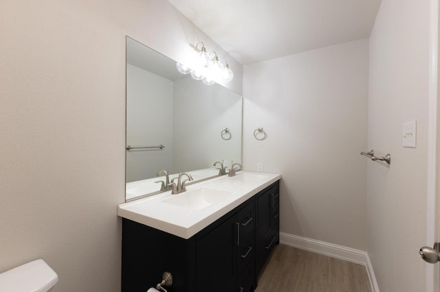 bathroom with wood-type flooring, toilet, and vanity