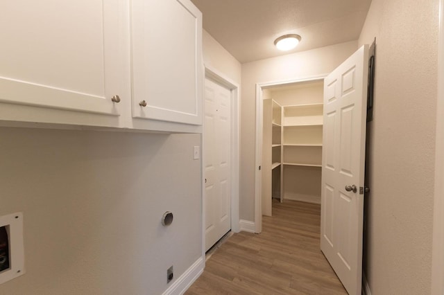 laundry area featuring hardwood / wood-style flooring, cabinets, hookup for a washing machine, and electric dryer hookup