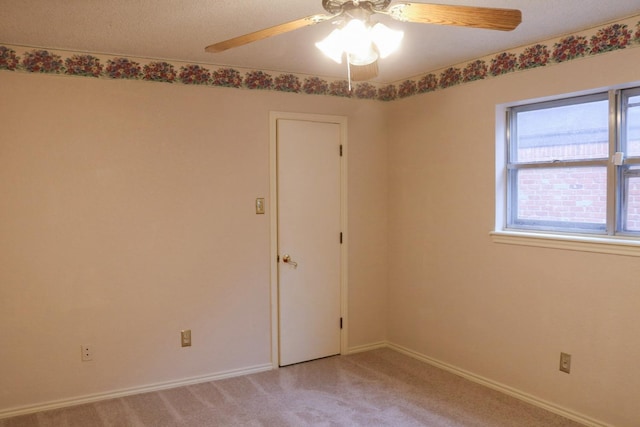 empty room featuring ceiling fan and light carpet