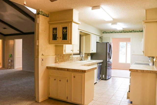 kitchen with stainless steel dishwasher, sink, a textured ceiling, and backsplash