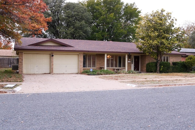 ranch-style house with a garage and cooling unit