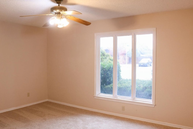 unfurnished room with ceiling fan, carpet flooring, and a textured ceiling