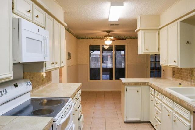 kitchen with white cabinets, light tile patterned floors, ceiling fan, kitchen peninsula, and white appliances